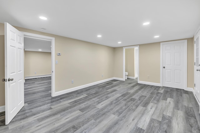 325 River Rd, Hamden, CT 06518 - finished basement with wood finished floors, a baseboard radiator, recessed lighting, and baseboards