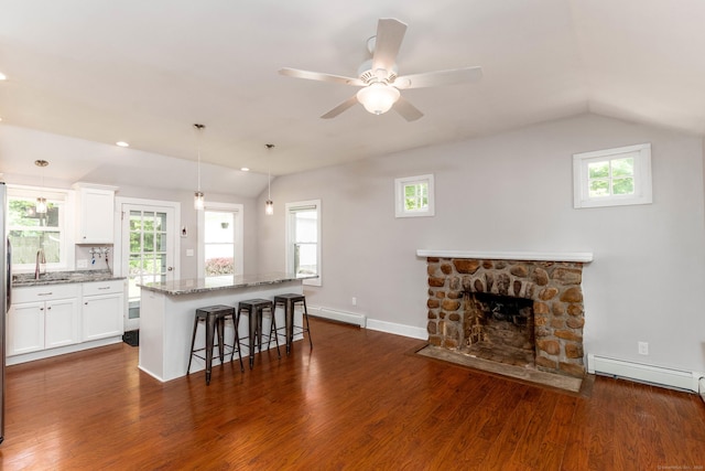 15 Seneca Rd, Middlefield, CT 06455 - kitchen with a sink, vaulted ceiling, light stone counters, dark wood-type flooring, and a breakfast bar