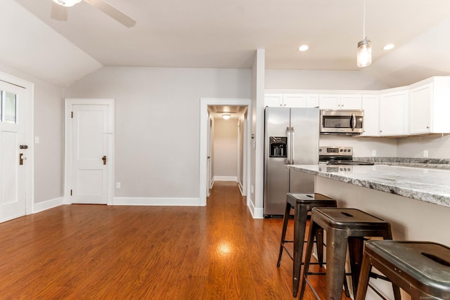 15 Seneca Rd, Middlefield, CT 06455 - kitchen featuring stainless steel appliances, a breakfast bar, vaulted ceiling, white cabinetry, and light stone counters