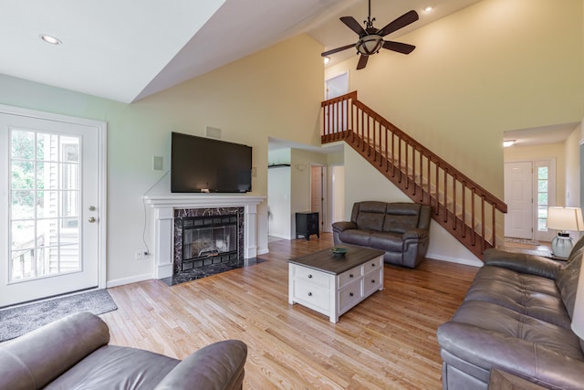 97 Spring Wood Ln, Bloomfield, CT 06002 - living room featuring stairway, high vaulted ceiling, light wood finished floors, a high end fireplace, and baseboards
