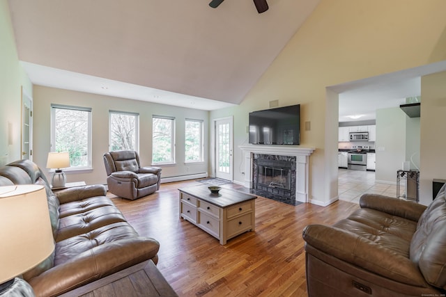 97 Spring Wood Ln, Bloomfield, CT 06002 - living room featuring baseboard heating, high vaulted ceiling, a fireplace, light wood finished floors, and healthy amount of natural light