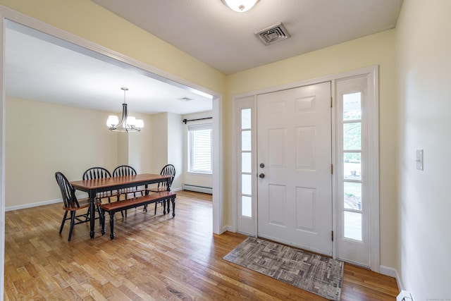 97 Spring Wood Ln, Bloomfield, CT 06002 - foyer entrance with a baseboard heating unit, a chandelier, light wood finished floors, and baseboards