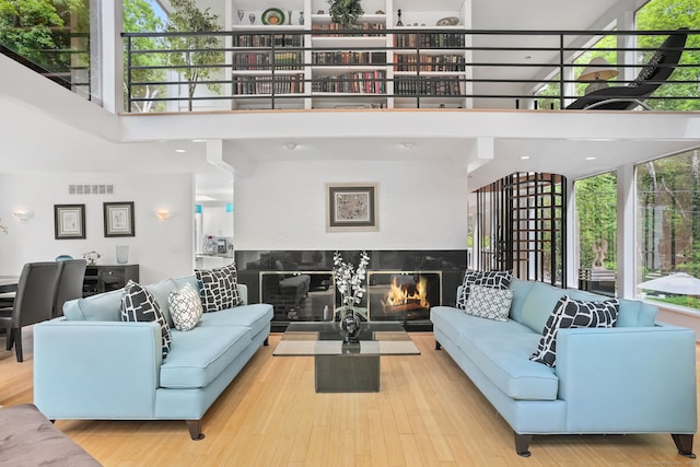227 Dublin Hill Rd, Southbury, CT 06488 - living area featuring a towering ceiling, a glass covered fireplace, and wood finished floors