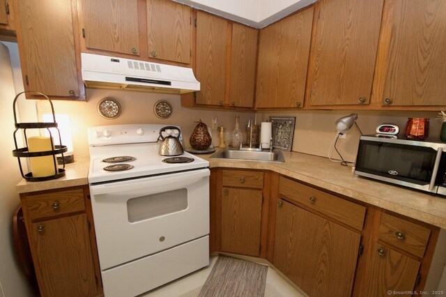 35 Mountain Village Rd Unit 15, Waterbury, CT 06706 - kitchen featuring white electric range, stainless steel microwave, under cabinet range hood, a sink, and light countertops