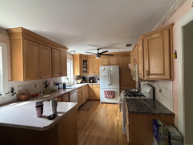 676 Deep River Rd, Colchester, CT 06415 - kitchen with white appliances, a peninsula, backsplash, a sink, and light wood finished floors