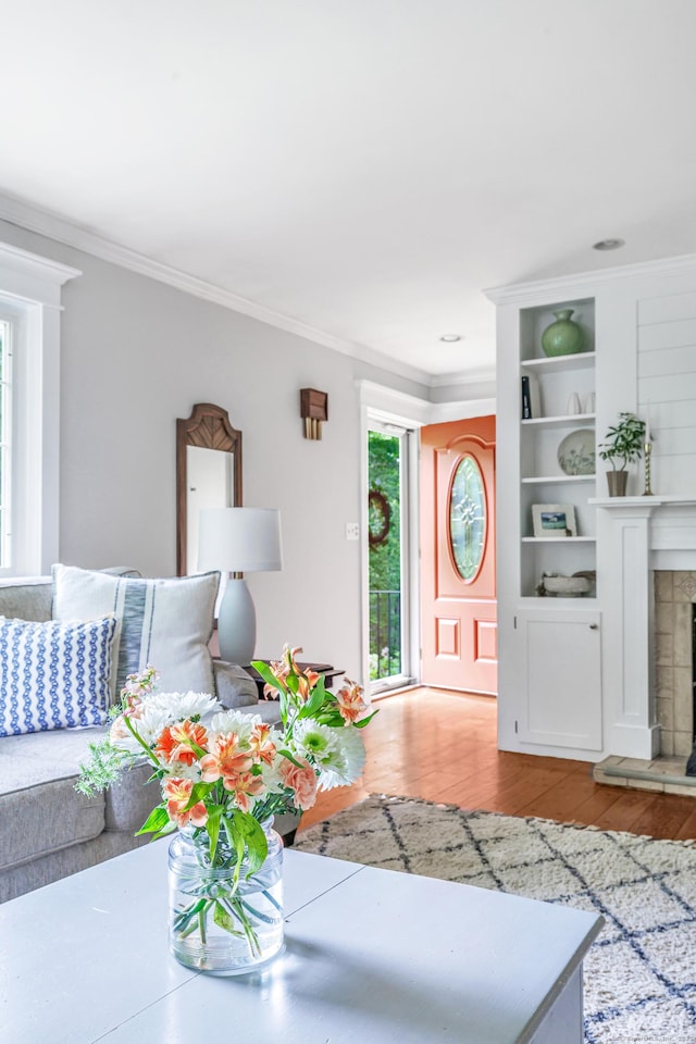 91 Bart Rd, Monroe, CT 06468 - living area with light wood-type flooring, ornamental molding, and a fireplace with raised hearth