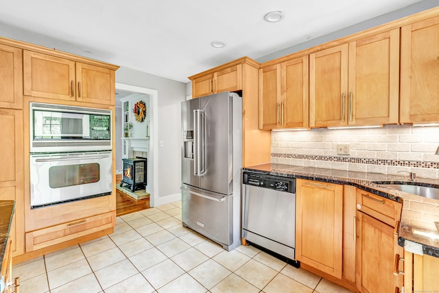 91 Bart Rd, Monroe, CT 06468 - kitchen with appliances with stainless steel finishes, backsplash, light tile patterned floors, a sink, and dark stone counters