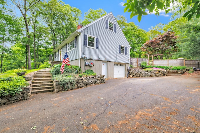 91 Bart Rd, Monroe, CT 06468 - view of side of property with a chimney, driveway, a garage, and stairway