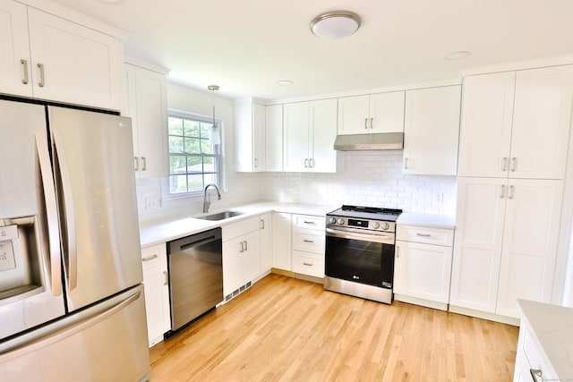 792 Cornwall Ave, Cheshire, CT 06410 - kitchen with appliances with stainless steel finishes, a sink, under cabinet range hood, light countertops, and light wood-type flooring