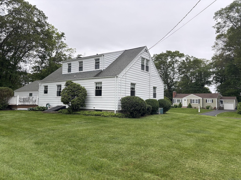 110 Cottage St, Trumbull, CT 06611 - view of side of property featuring a lawn, a wooden deck, and a shingled roof