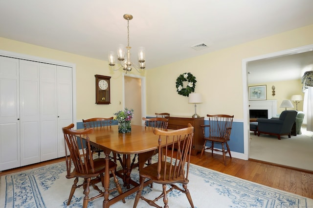 110 Cottage St, Trumbull, CT 06611 - dining area with wood finished floors, a chandelier, and a fireplace