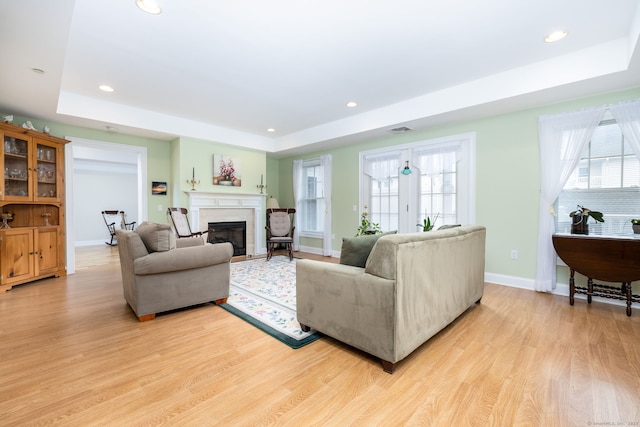237 Fern St Apt 206W, West Hartford, CT 06119 - living area featuring a raised ceiling, light wood-style floors, a glass covered fireplace, and recessed lighting