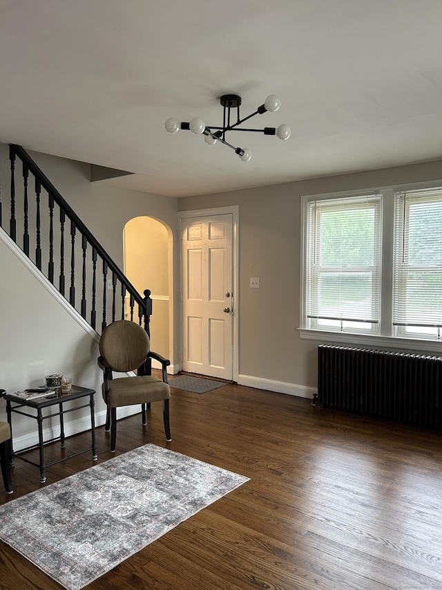 146 Knowlton St, Stratford, CT 06615 - entryway featuring radiator heating unit, arched walkways, a chandelier, baseboards, and dark wood finished floors