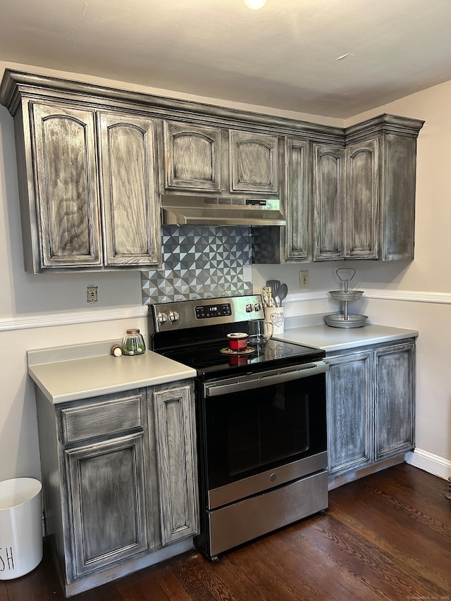 146 Knowlton St, Stratford, CT 06615 - kitchen featuring stainless steel electric stove, under cabinet range hood, light countertops, dark wood finished floors, and decorative backsplash