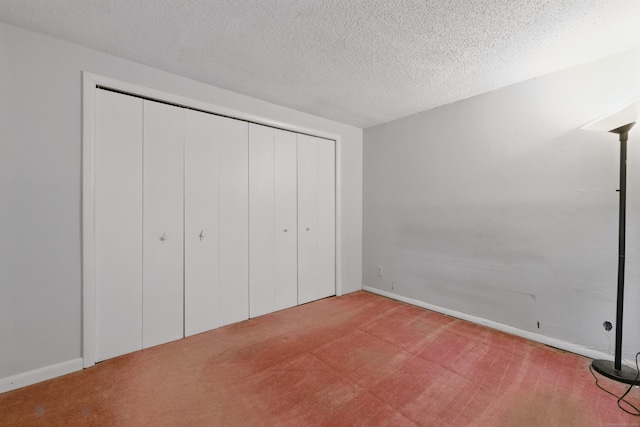 23 Fenwick Ct, Groton, CT 06355 - unfurnished bedroom featuring carpet floors, a textured ceiling, and a closet
