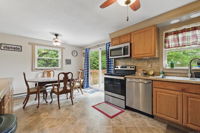 23 Fenwick Ct, Groton, CT 06355 - kitchen featuring stainless steel appliances, plenty of natural light, a sink, backsplash, and a textured ceiling