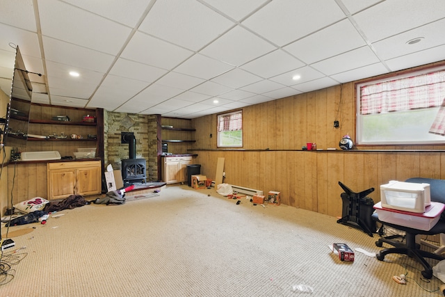 23 Fenwick Ct, Groton, CT 06355 - workout area with a wood stove, carpet flooring, wooden walls, a paneled ceiling, and a baseboard heating unit