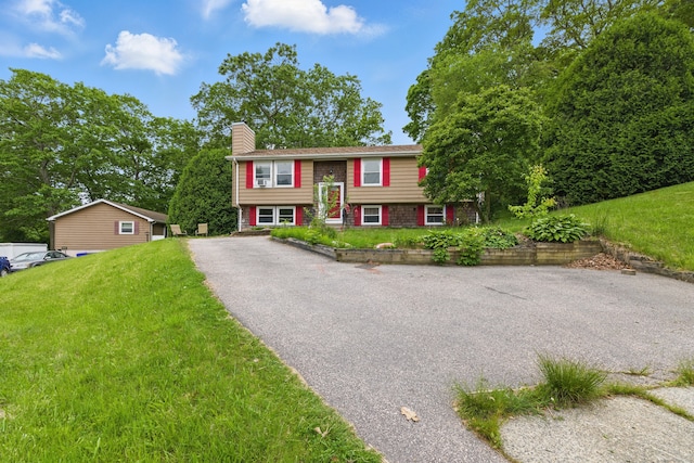 23 Fenwick Ct, Groton, CT 06355 - split foyer home featuring a chimney, a front lawn, and driveway