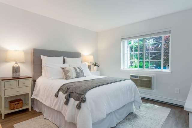 2955 Madison Ave Apt 25, Bridgeport, CT 06606 - bedroom featuring wood finished floors, a wall mounted air conditioner, and a baseboard heating unit