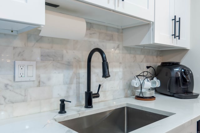 2955 Madison Ave Apt 25, Bridgeport, CT 06606 - kitchen view of a sink, decorative backsplash, white cabinets, and light stone counters