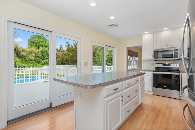 31 Elizabeth St, Shelton, CT 06484 - kitchen with appliances with stainless steel finishes, light wood-style flooring, white cabinetry, a center island, and recessed lighting