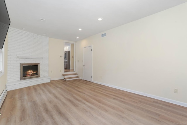 31 Elizabeth St, Shelton, CT 06484 - unfurnished living room featuring light wood-type flooring, baseboards, recessed lighting, and a brick fireplace