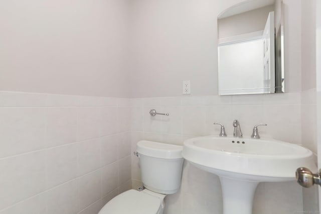 31 Elizabeth St, Shelton, CT 06484 - bathroom with toilet, tile walls, a sink, and wainscoting