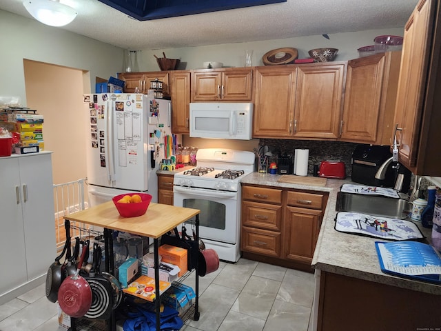 4 Lynn Ln, Windsor Locks, CT 06096 - kitchen with white appliances, brown cabinetry, light countertops, light tile patterned floors, and a textured ceiling