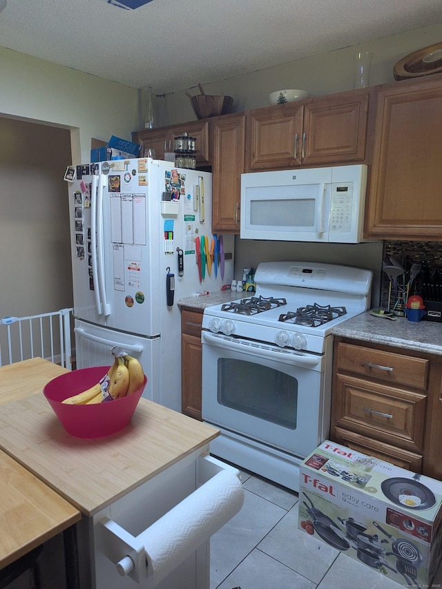 4 Lynn Ln, Windsor Locks, CT 06096 - kitchen with white appliances, brown cabinetry, and tile patterned flooring