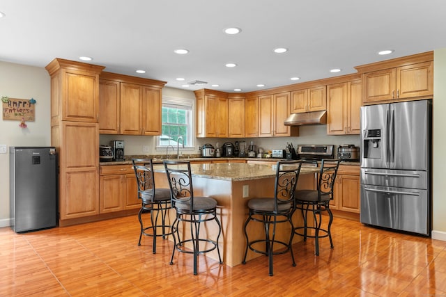 3657 Park Ave, Fairfield, CT 06825 - kitchen featuring stainless steel appliances, recessed lighting, a breakfast bar, light wood-style floors, and a center island