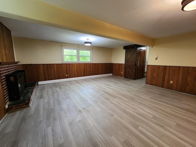 176 Hanover Rd, Newtown, CT 06470 - unfurnished living room with a wainscoted wall, light wood-style flooring, a brick fireplace, and wood walls