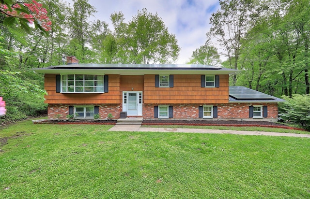 408 Reservoir Rd, Southbury, CT 06488 - raised ranch featuring roof mounted solar panels, a front lawn, a chimney, and brick siding