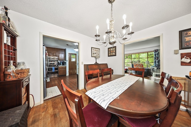 408 Reservoir Rd, Southbury, CT 06488 - dining room with a chandelier, dark wood finished floors, and a textured ceiling