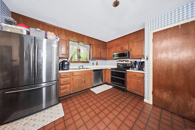 408 Reservoir Rd, Southbury, CT 06488 - kitchen featuring stainless steel appliances, a sink, light countertops, a textured ceiling, and decorative backsplash