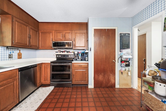 408 Reservoir Rd, Southbury, CT 06488 - kitchen with appliances with stainless steel finishes, wallpapered walls, light countertops, a textured ceiling, and tasteful backsplash