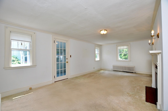 27 Prospect St, Bloomfield, CT 06002 - unfurnished living room featuring radiator heating unit, crown molding, carpet floors, a fireplace with flush hearth, and baseboards