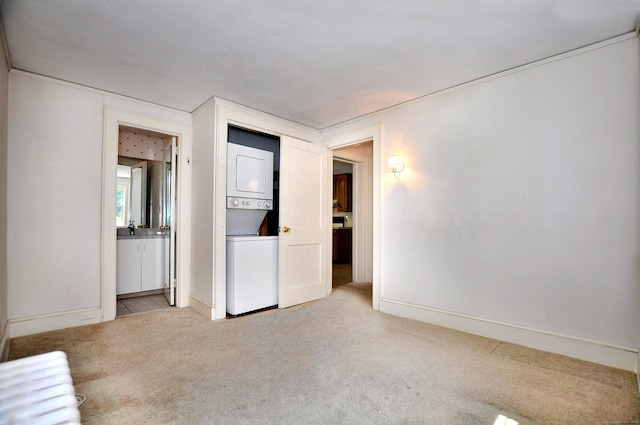 27 Prospect St, Bloomfield, CT 06002 - unfurnished bedroom featuring stacked washing machine and dryer, light carpet, baseboards, and ensuite bathroom