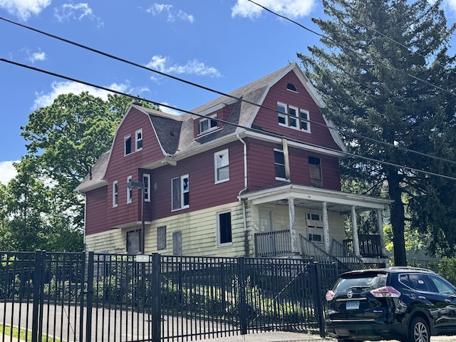 50 Elmwood Ave, Waterbury, CT 06710 - view of front of house featuring a porch, a fenced front yard, a gambrel roof, and a shingled roof