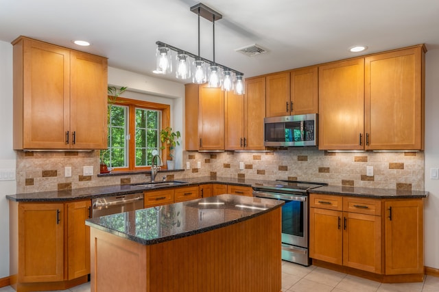 113 Charles St, Tolland, CT 06084 - kitchen with stainless steel appliances, a sink, a center island, dark stone counters, and tasteful backsplash