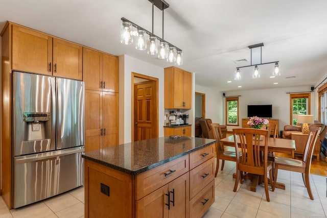113 Charles St, Tolland, CT 06084 - kitchen with stainless steel refrigerator with ice dispenser, light tile patterned floors, open floor plan, dark stone counters, and a center island