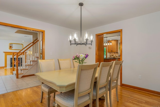 113 Charles St, Tolland, CT 06084 - dining area featuring a chandelier, light wood-style flooring, and baseboards