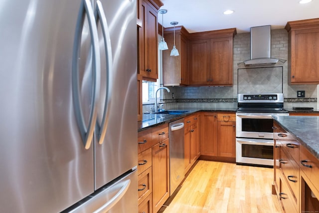 613 Ridgewood Rd, Middletown, CT 06457 - kitchen with appliances with stainless steel finishes, wall chimney range hood, light wood finished floors, a sink, and brown cabinetry