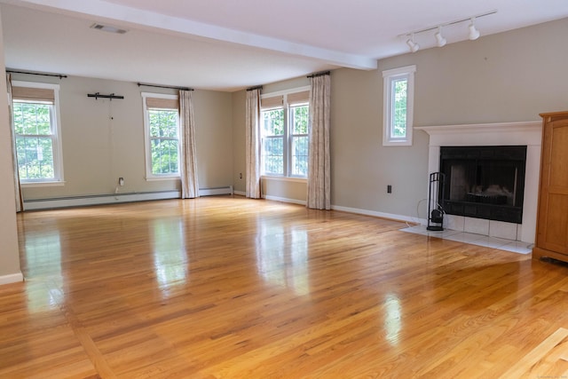 613 Ridgewood Rd, Middletown, CT 06457 - unfurnished living room featuring rail lighting, a tiled fireplace, light wood-type flooring, baseboards, and a baseboard heating unit