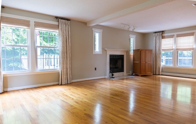 613 Ridgewood Rd, Middletown, CT 06457 - unfurnished living room featuring a baseboard radiator, wood finished floors, track lighting, and baseboards