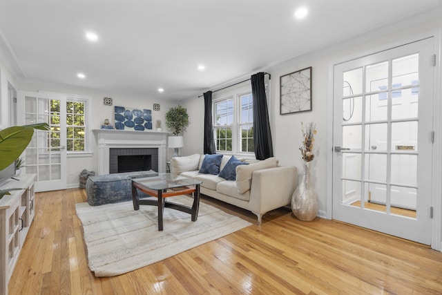 182 5th St, Stamford, CT 06905 - living area with crown molding, healthy amount of natural light, a brick fireplace, light wood-type flooring, and recessed lighting