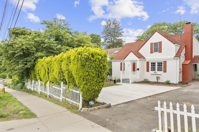 182 5th St, Stamford, CT 06905 - view of front of house with a chimney, a tiled roof, brick siding, and stucco siding