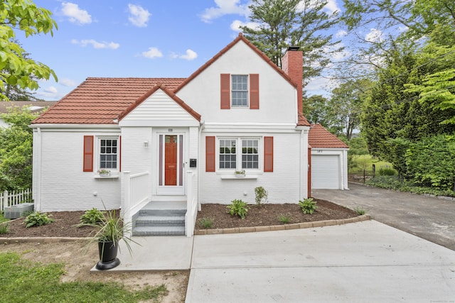 182 5th St, Stamford, CT 06905 - view of front of home featuring a chimney, concrete driveway, a tile roof, brick siding, and cooling unit