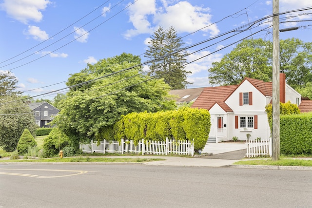 182 5th St, Stamford, CT 06905 - view of front facade with a fenced front yard, a tile roof, stucco siding, and a chimney
