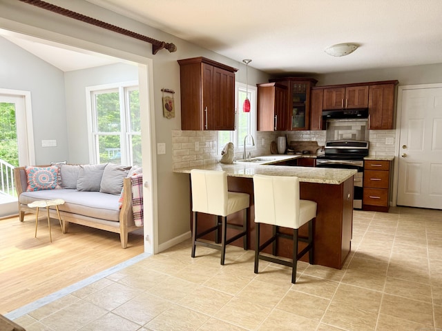 273 New London Rd, Colchester, CT 06415 - kitchen featuring stainless steel range with electric stovetop, a peninsula, decorative backsplash, under cabinet range hood, and lofted ceiling