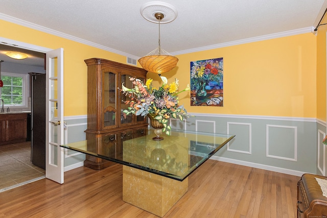 273 New London Rd, Colchester, CT 06415 - dining area featuring wainscoting, wood finished floors, and ornamental molding